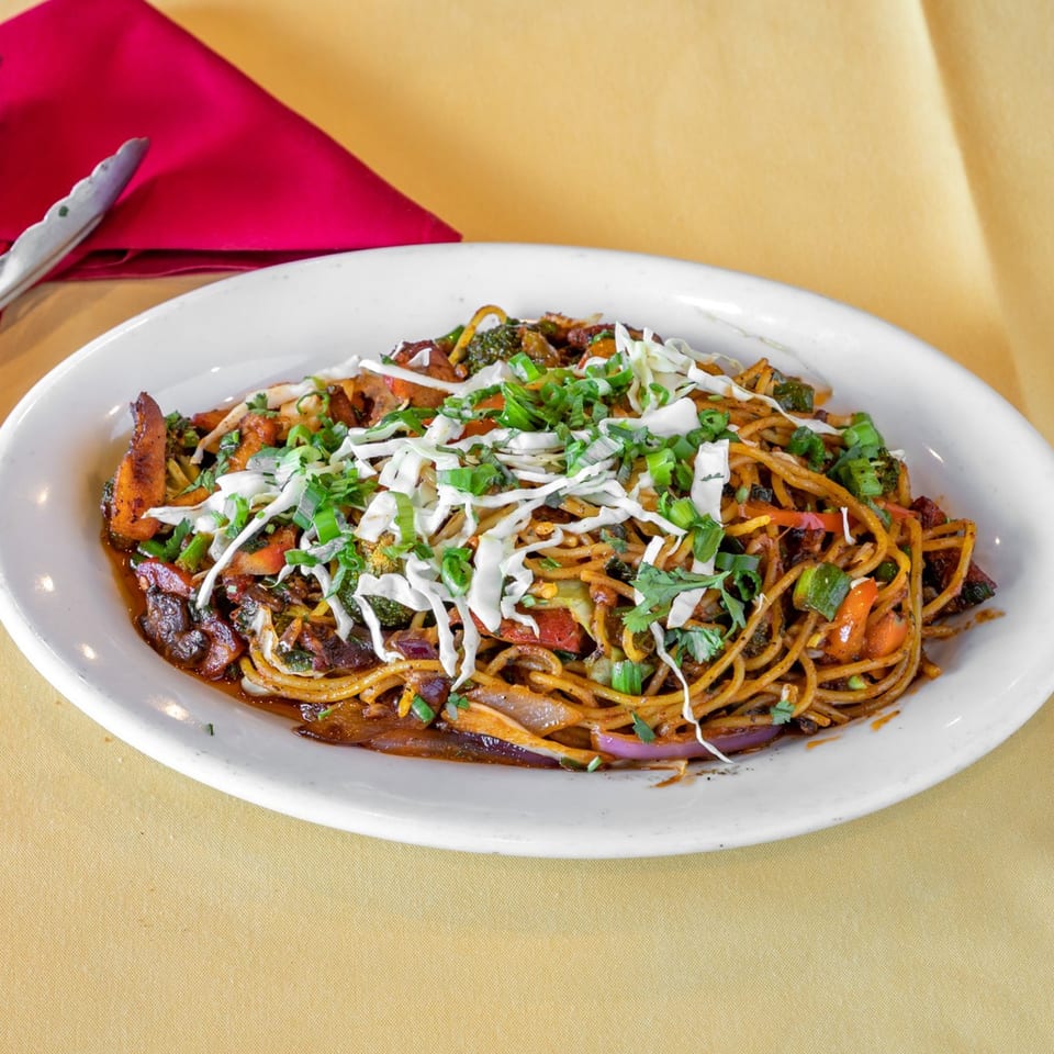 Himalayan Kitchen's Indian chowmein noodles with vegetables, topped with shredded cabbage and green onions.